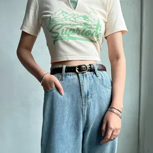 Women casual short sleeve crop top with stylish blue denim jeans and vintage brown belt set.