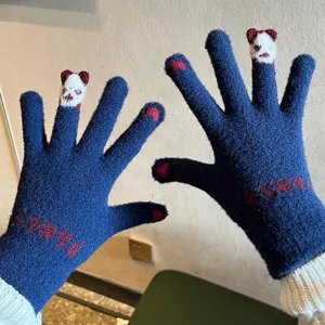 Detail view of cute winter knitted gloves for women with panda design and warm touch screen feature.