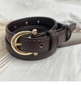 Primo piano dettagliato di un'elegante cintura in pelle marrone scuro con fibbia dorata.