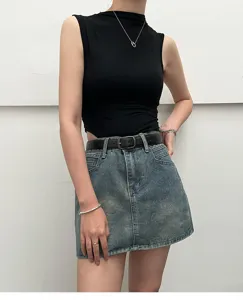Close-up detailed view of the stylish black sleeveless top, denim mini skirt and black belt.