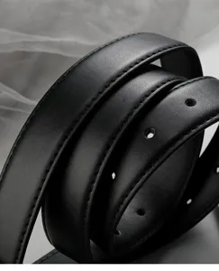 Close up detail of black leather belt showing fine stitching and classic minimalist design.