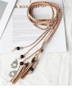 Gros plan détaillé d'une corde de taille tressée vintage à pompons, ceinture ethnique.