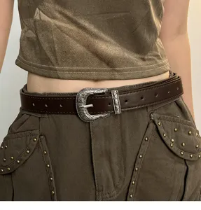 Vintage western metal buckle brown leather belt detail shot showcasing retro carved design.