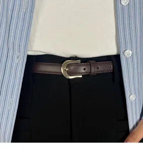 Brown leather belt detail close-up, minimalist retro metal buckle design for stylish outfits.