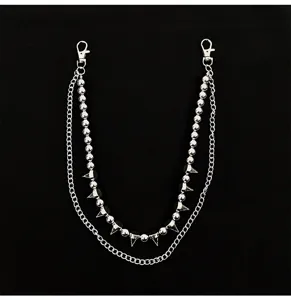 Close-up detail of silver double layer punk pants chain with beads and metal spikes.