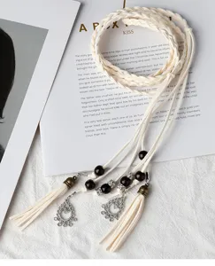 Vue détaillée de la ceinture tressée rétro avec des glands et perles en bois.