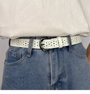 Detailed white hollow-out women's belt showing unique patterns and sleek metal buckle.