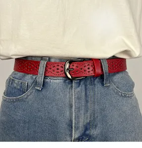 Close-up detail of red hollow-out leather belt, stylish waist accessory for jeans.