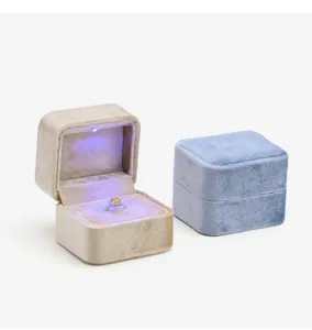 Velvet ring box featuring built-in LED light and elegant square design for jewelry presentation.
