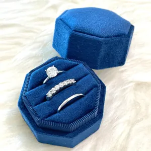 Boîte à bague octogonale en velours bleu avec trois fentes pour alliances et bagues.