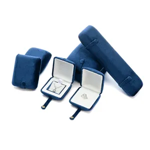 Dark blue velvet jewelry boxes set for rings, necklaces, and bracelets. Elegant gift packaging.