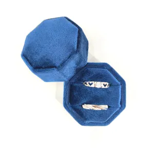 Blauwe fluwelen ringdoos met twee zilveren ringen, elegante achthoekige sieraden geschenkdoos.
