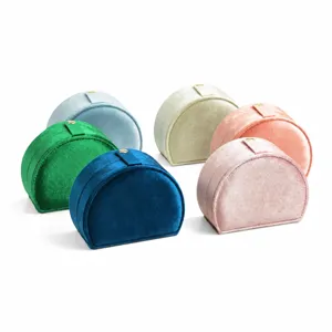 Portable velvet jewelry box for travel storage, elegant half-round display case for rings.
