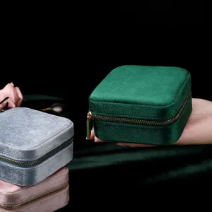Portable velvet zipper jewelry box for rings and necklaces, elegantly displayed in hand.