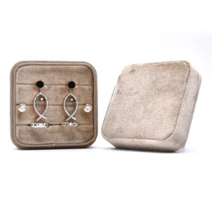 Brown velvet jewelry storage box set featuring elegant fish earrings and stylish rings.
