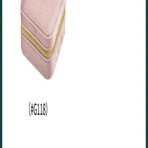 Primo piano della scatola per gioielli in velluto rosa con morbida texture e zip dorata.