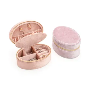 Portable pink oval velvet jewelry box with zipper, ring slots and compartments for travel.
