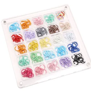 Detailansicht bunter lackierter Eisen-Biegeringe in transparenter Acryl-Sortierbox.