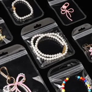 Transparent self-sealing bags with assorted DIY jewelry accessories, pearl and bead bracelets.