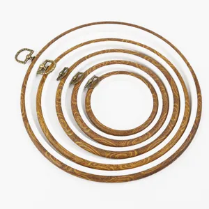 Gros plan détaillé des cadres de broderie imitation bois emboîtés avec anneau en bronze.