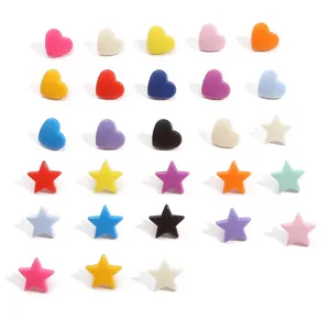 Gros plan de boutons-pression colorés en résine en forme de cœur et d'étoile pour accessoires.