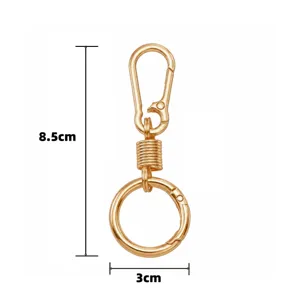 Gold alloy keychain accessory detail, spring hook and round ring design, compact and durable.