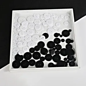 Detailansicht schwarzer und weißer runder Harzknöpfe, ideal für DIY-Basteln und Kleidung.