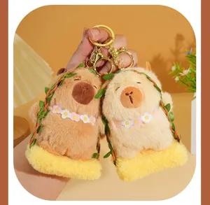 Close-up detail of cute capybara plush keychain set with flower garland and mini swing.