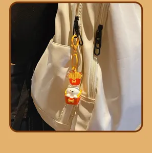 Cute cartoon dog and french fries keychain detail view, perfect backpack accessory charm.
