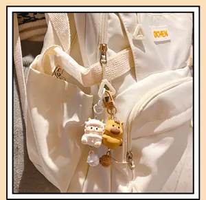 Cute white backpack with adorable zodiac keychains, perfect for daily casual use and school.