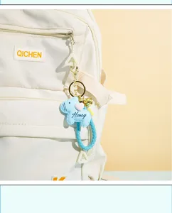 Close-up detail of the cute leather horse keychain bag charm with heart and braided strap.