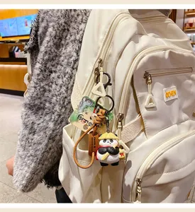 Detailed close-up shot of the cute panda keychain hanging on a white backpack accessory.