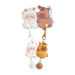 Cute zodiac animal couple keychain charm with bells and backpack accessory design.