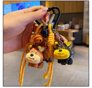 Close-up detail of cute DIY resin puppy bee keychain with yellow braided rope and black carabiner.