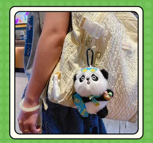 Cute panda plush keychain detail showing skateboard accessory hanging on quilted backpack smoothly.