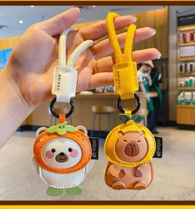 Cute cartoon leather capybara and bear keychain with fruit hat design, ideal bag charm accessory.