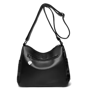 Detailansicht der schwarzen Ledertasche mit Vordertasche und verstellbarem Schultergurt.