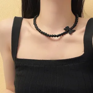 Gedetailleerde close-up van de zwarte kralenketting met strikhanger om de mooie hals.