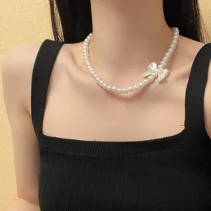 Detailopname van de elegante parel choker halsketting met een schattig strikdesign aan de zijkant.