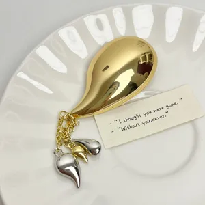 Detail view of the French retro metal teardrop chili brooch with chic dangling tassels.