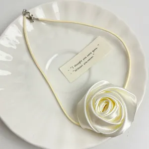 Fabric rose choker necklace detail, elegant white floral design with thin cord accessory.