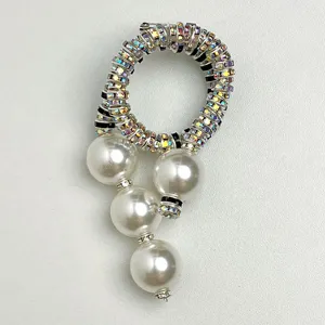 Detailopname van een luxe strass spiraal parelbroch met sprankelende kristallen en glanzende parels.