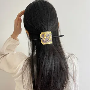 Detailed view of Chinese style metal enamel hair stick with floral and bird motif.