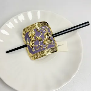 Detailed view of Chinese style metal hair stick with purple enamel and dual lion design.