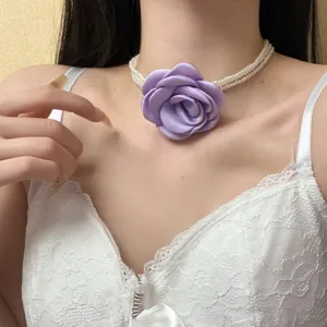 Prachtige meerlaagse parel choker halsketting met elegante paarse stoffen roos bloem detail.