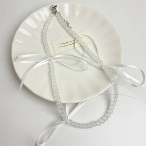 Witte kralen choker ketting detail met elegante lintstrik voor zoete bosstijl.