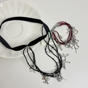 Nahaufnahme des gotischen schwarzen Samt-Chokers und der roten Perlen-Kreuz-Halskette.