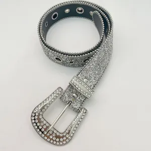 Detailed view of sparkling rhinestone women belt with metal eyelets and glitter finish.