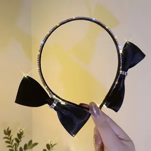 Black satin bow headband with sparkling rhinestones, elegant hair accessory for women.