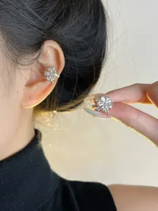 Detalle de manguito de oreja de girasol de circonita delicada con piedras de cristal brillantes.